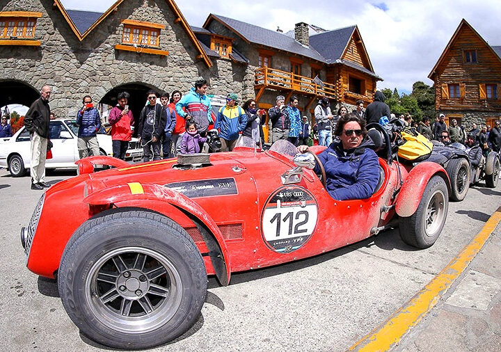 Auto sport clásico rojo de las 1000 Millas Sport rodeado de público en el Centro Cívico de Bariloche