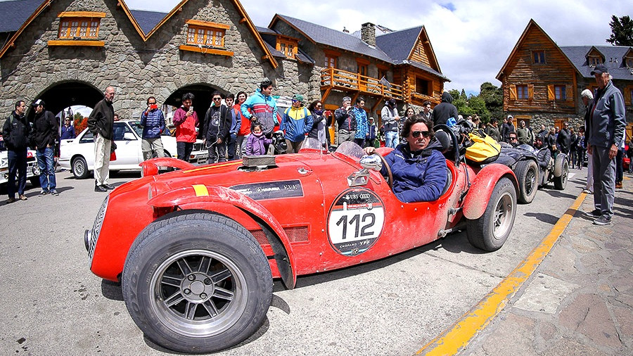 Auto sport clásico rojo de las 1000 Millas Sport rodeado de público en el Centro Cívico de Bariloche