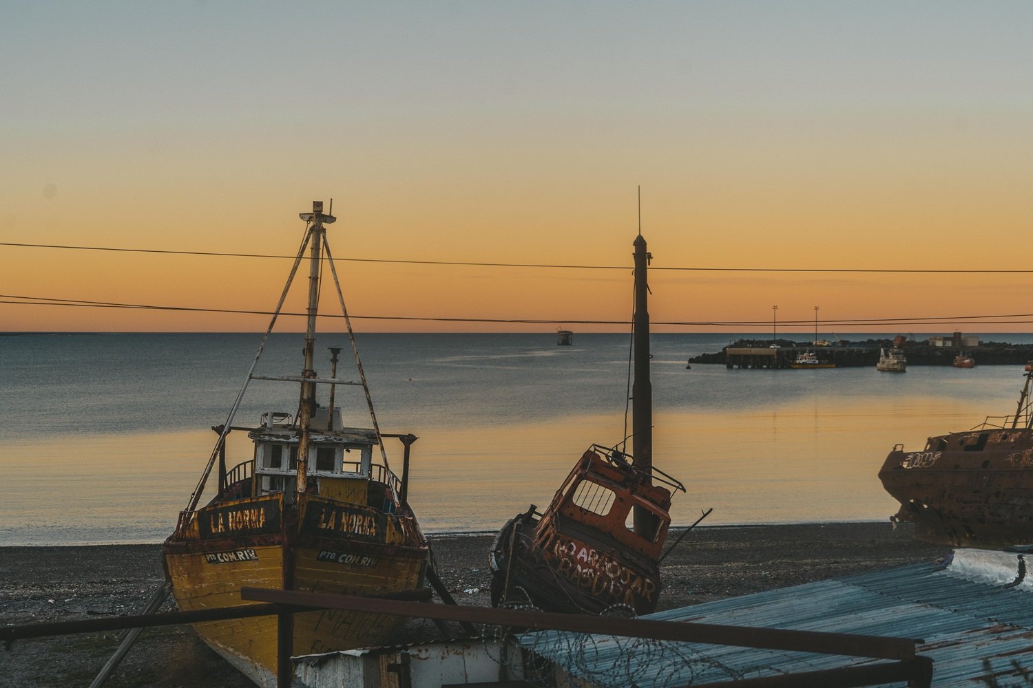 Barcos pesqueros varados en la playa de Caleta Córdova al atardecer, Comodoro Rivadavia