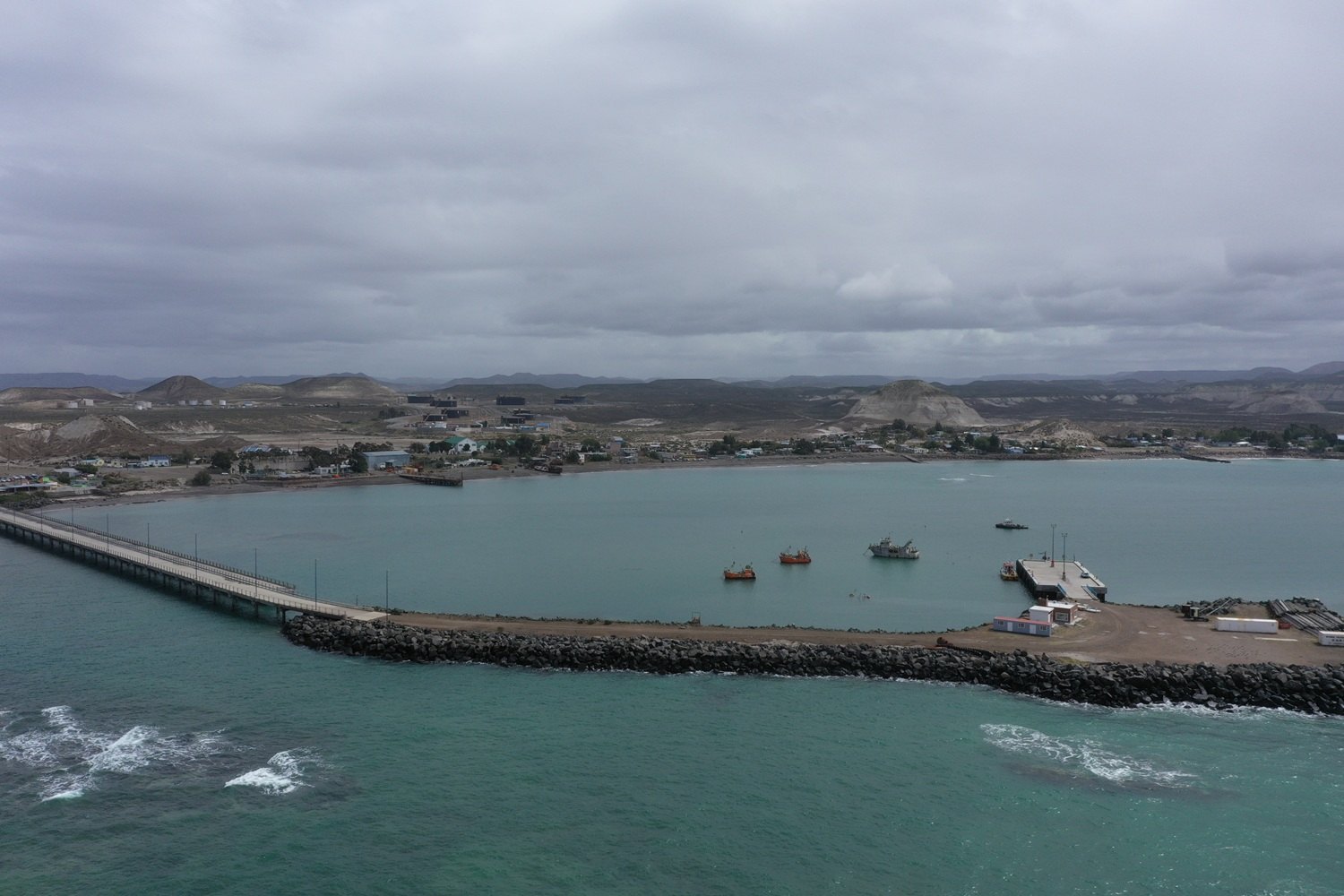 Vista aérea de la bahía de Caleta Córdova con su muelle y barcos pesqueros, Comodoro Rivadavia
