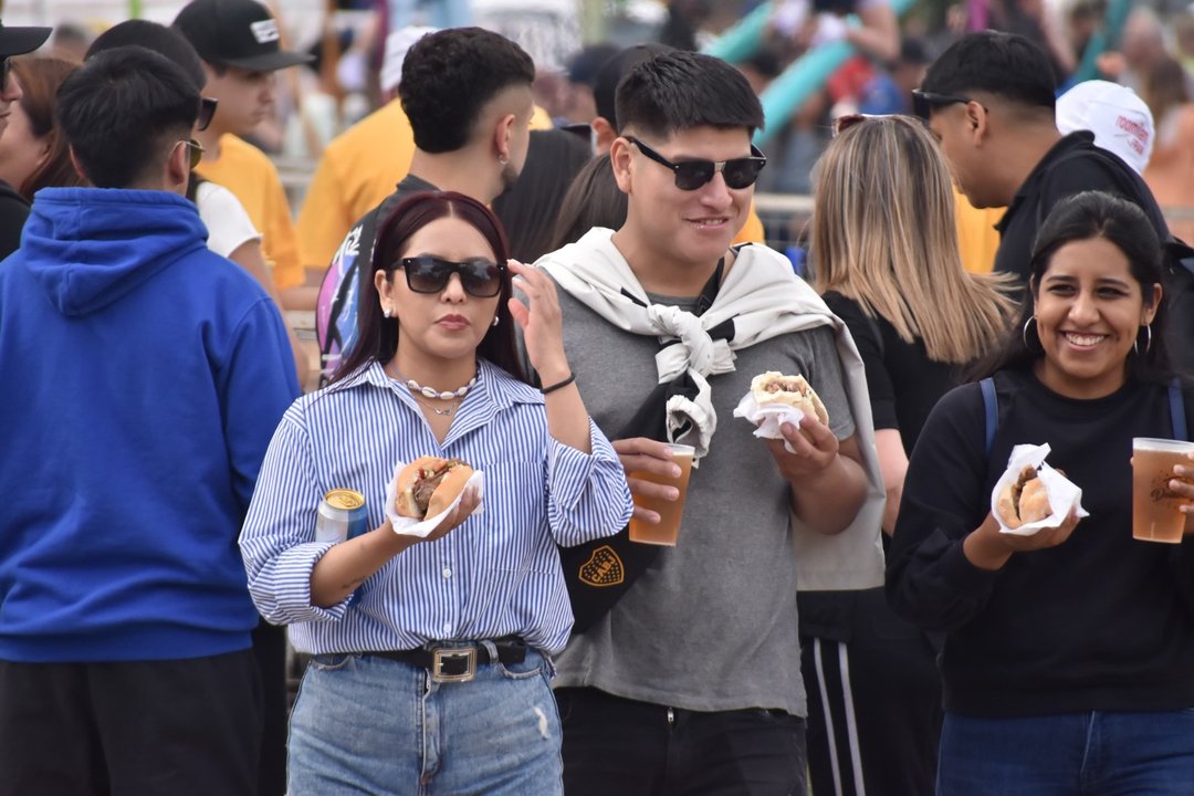 Visitantes comiendo choripanes y tomando cerveza en el Chorilavon, la fiesta del chorizo de Dolavon