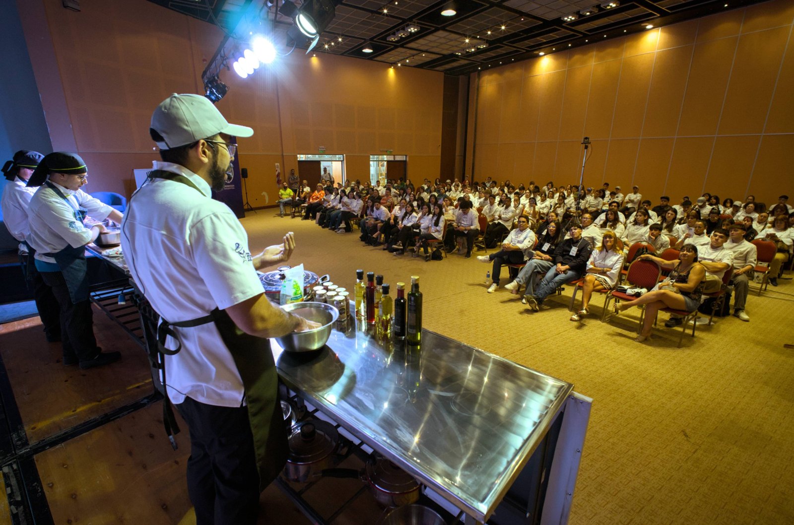 Chefs cocinando en vivo frente a estudiantes de gastronomía en una masterclass de CocinARTE