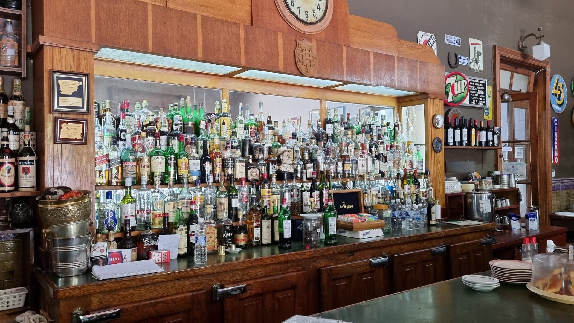 La barra de madera con el reloj y cientos de botellas en la Confitería del Hotel Touring Club, Trelew