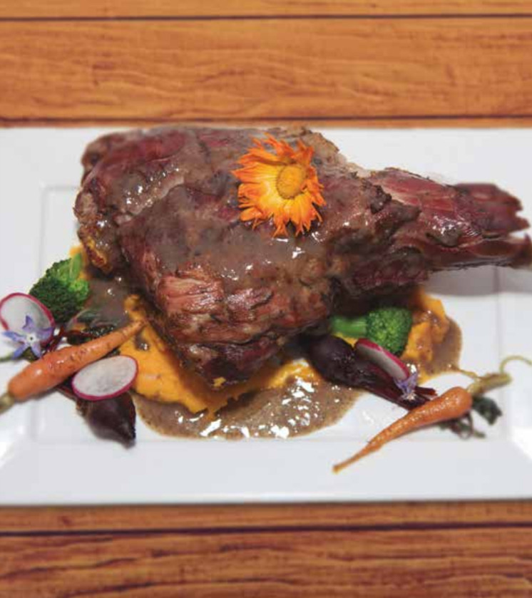 Pierna de cordero patagónico sobre puré de calabaza y zanahoria con vegetales baby caramelizados