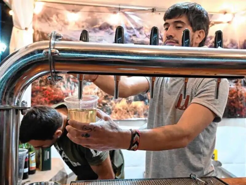 Un expendedor sirve sidra tirada en un vaso durante el Festival de la Sidra de General Roca