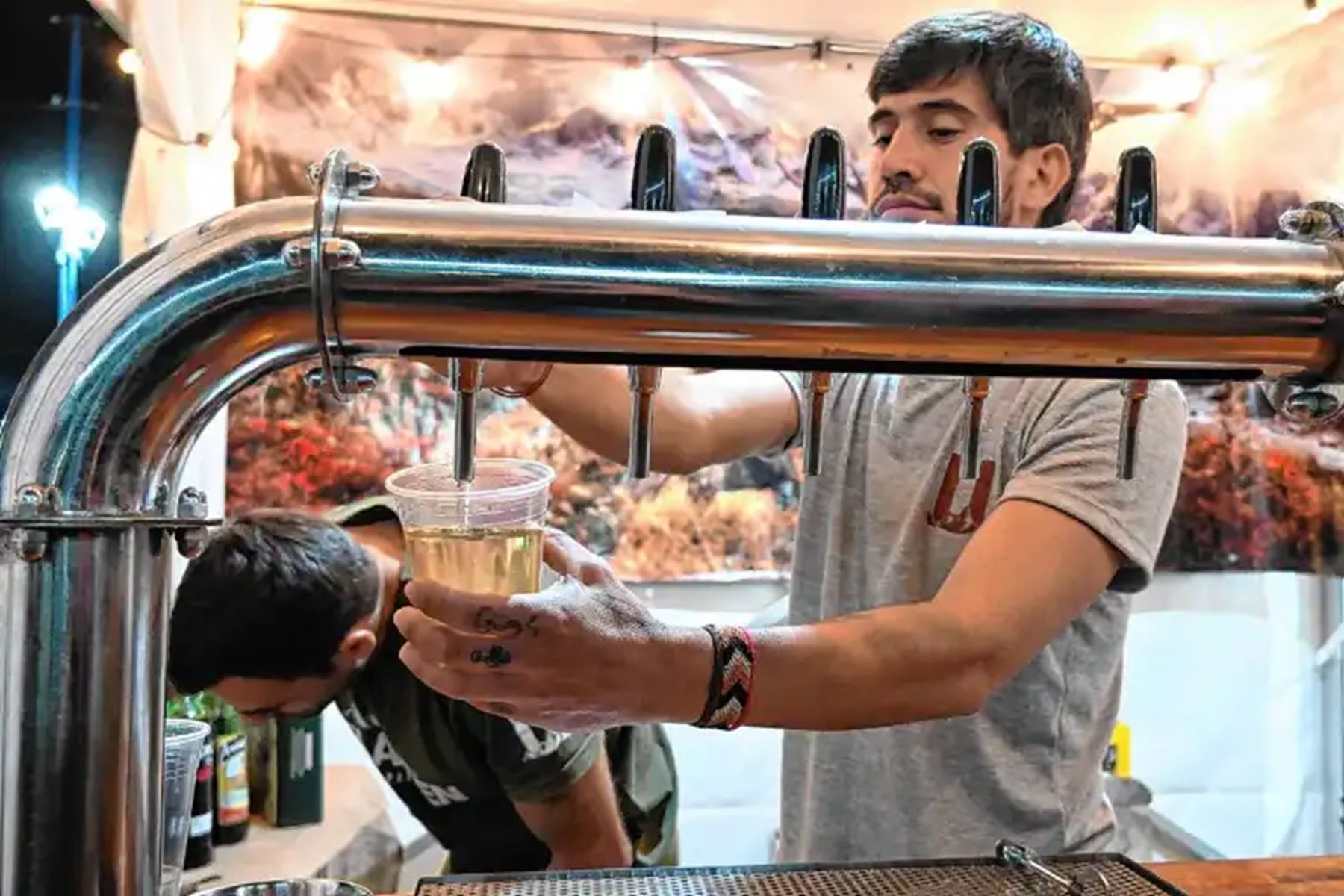 Un expendedor sirve sidra tirada en un vaso durante el Festival de la Sidra de General Roca