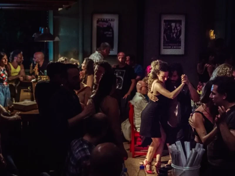 Parejas bailando tango en una milonga a media luz, propuesta del Festival Muy Tango que llega a Bariloche