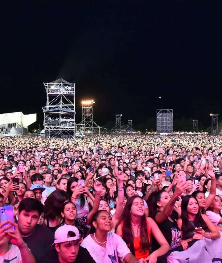 Multitud frente al escenario de la Fiesta Nacional de la Confluencia en la Isla 132 de Neuquén, de noche