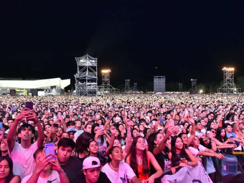Multitud frente al escenario de la Fiesta Nacional de la Confluencia en la Isla 132 de Neuquén, de noche