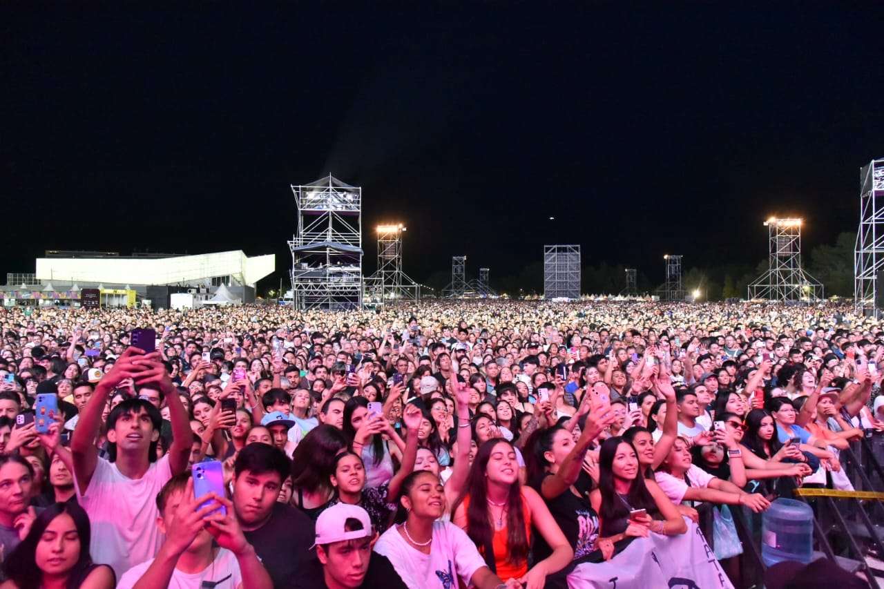 Multitud frente al escenario de la Fiesta Nacional de la Confluencia en la Isla 132 de Neuquén, de noche