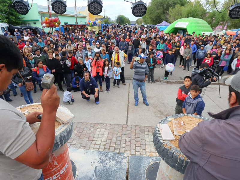 Abuñadores trabajando la piedra laja con martillo frente al público en la Fiesta Nacional de la Piedra Laja, en Los Menucos, Río Negro