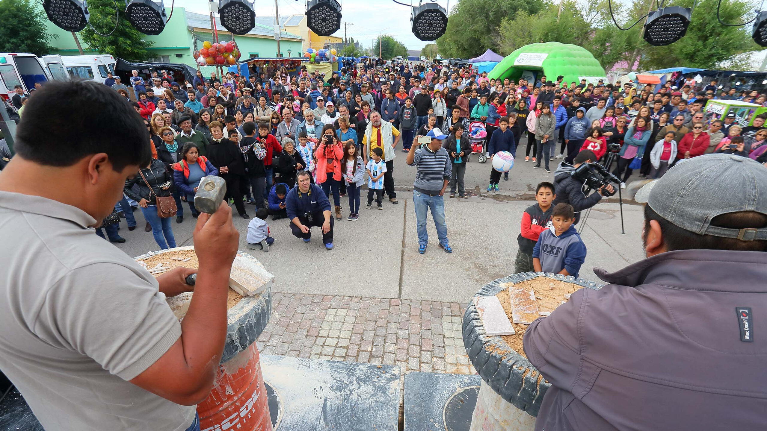 Abuñadores trabajando la piedra laja con martillo frente al público en la Fiesta Nacional de la Piedra Laja, en Los Menucos, Río Negro