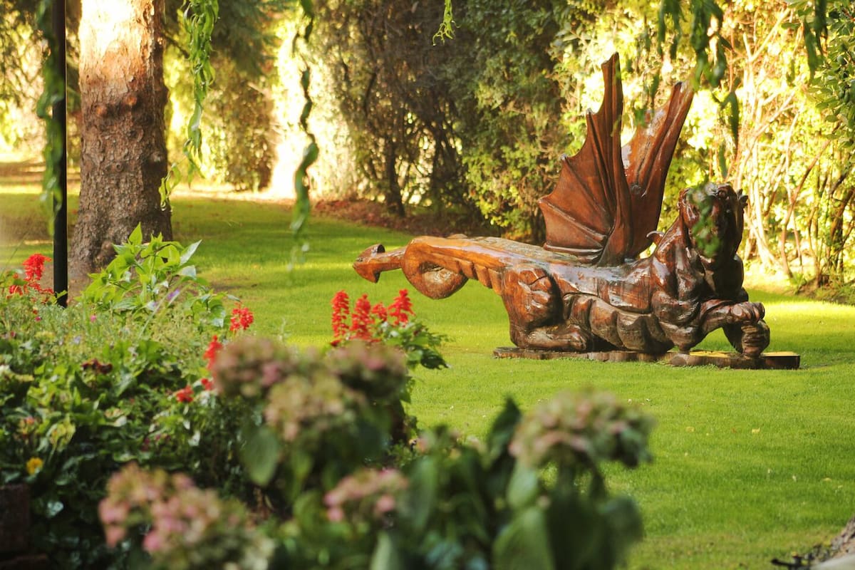 Dragón galés tallado en madera en un jardín de Gaiman, Chubut