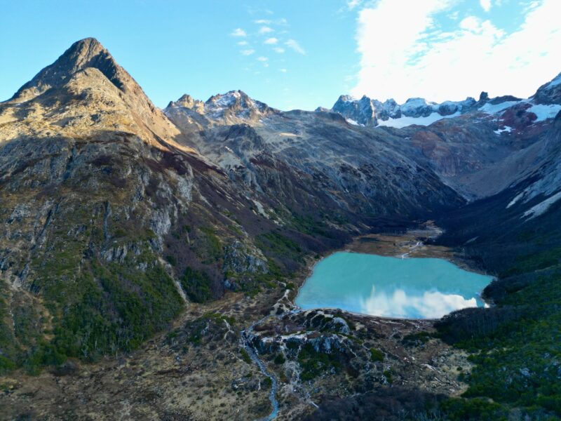 Vista aérea de la Laguna Esmeralda rodeada de bosques y montañas cerca de Ushuaia, Tierra del Fuego