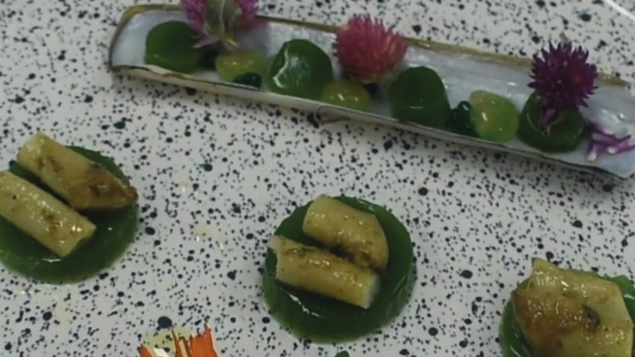 Navajas de mar del Golfo San Matías sobre velo de rúcula, con falso caviar de riesling y pera, servidas en su valva