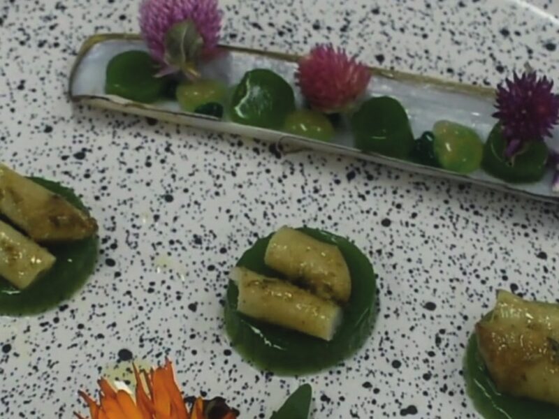 Navajas de mar del Golfo San Matías sobre velo de rúcula, con falso caviar de riesling y pera, servidas en su valva