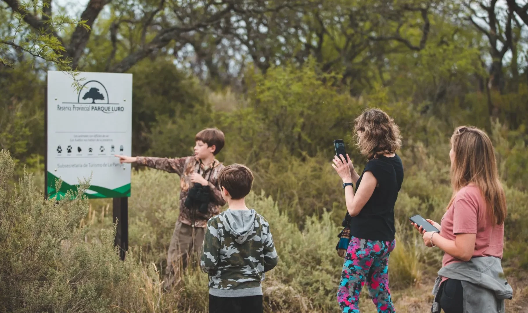 Familia recorriendo un sendero entre caldenes en la Reserva Provincial Parque Luro, La Pampa