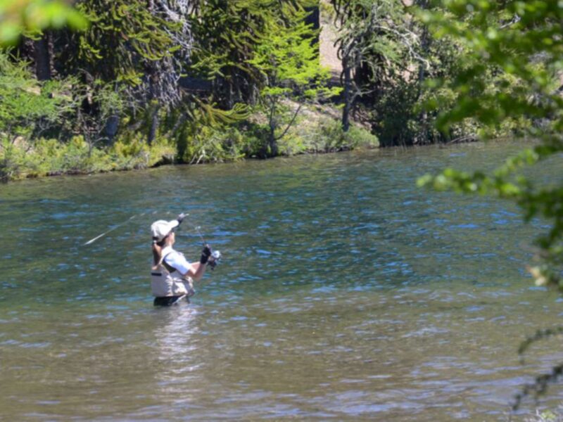 Pescador con caña en un río de la cordillera neuquina