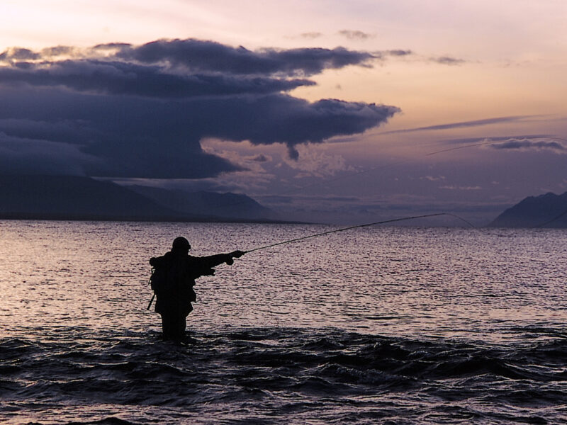 Pescador con caña de mosca al atardecer en un río de Tierra del Fuego