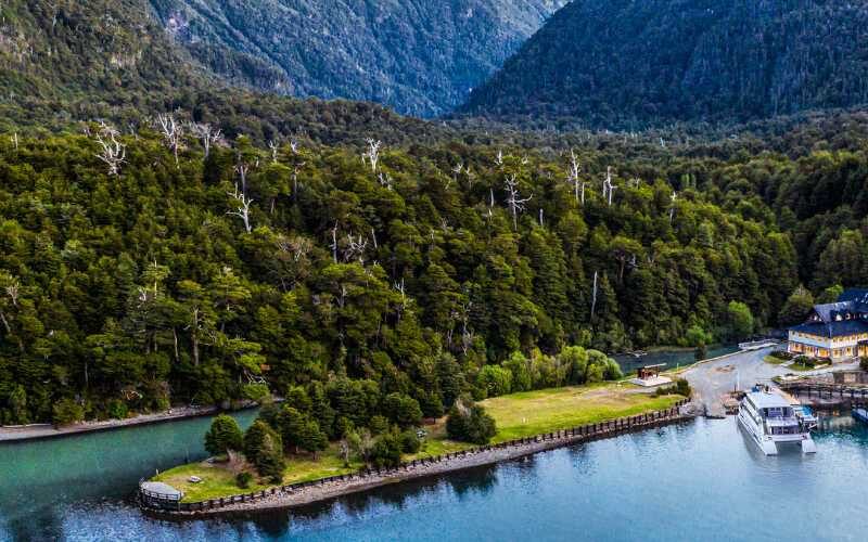 Vista aérea de Puerto Blest con su muelle y la hostería rodeados de selva valdiviana, sobre las aguas turquesa del Brazo Blest del lago Nahuel Huapi