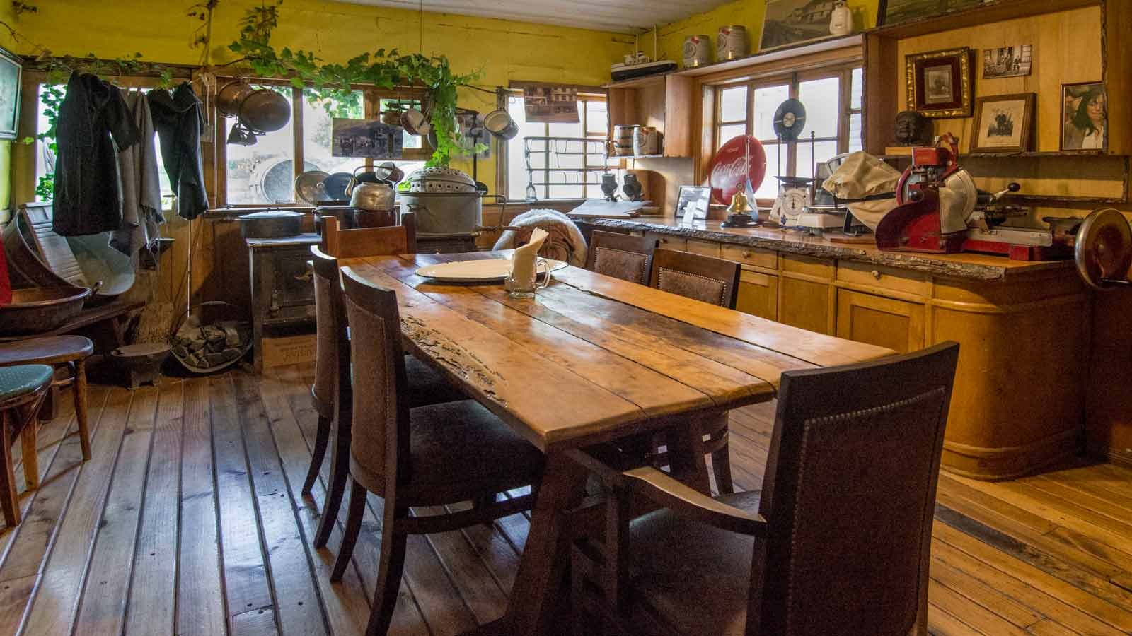 Salón de madera con araña de caireles y cartel antiguo en Ramos Generales, Ushuaia