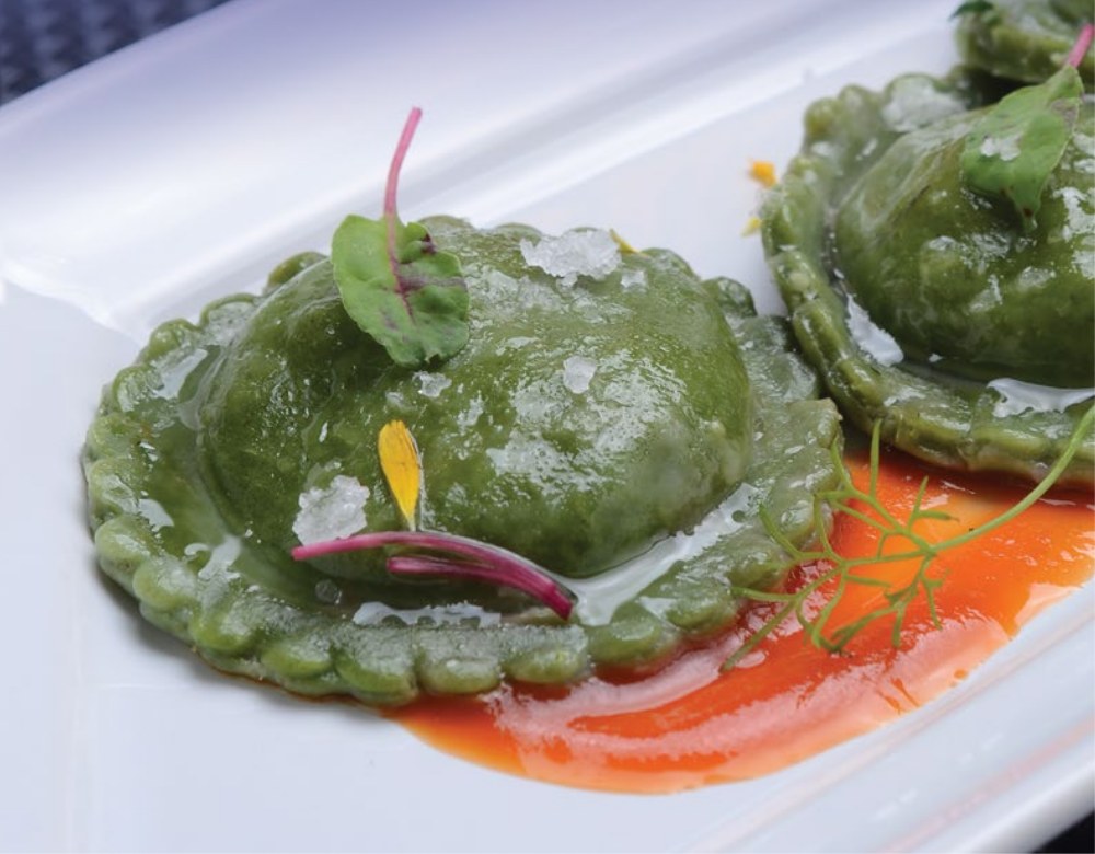 Emplatado de sorrentinos verdes rellenos de langostino con salsa de pimientos asados