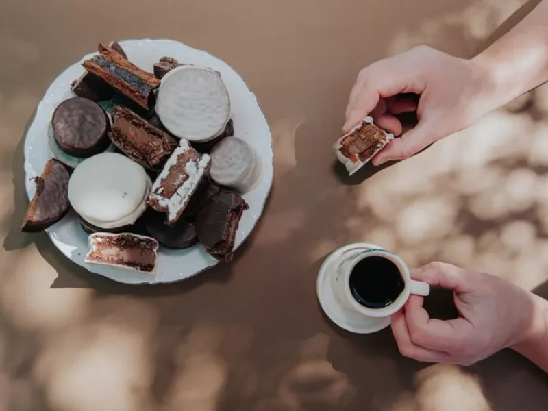 Plato con alfajores artesanales de chocolate blanco y negro de TemplArte junto a una taza de café