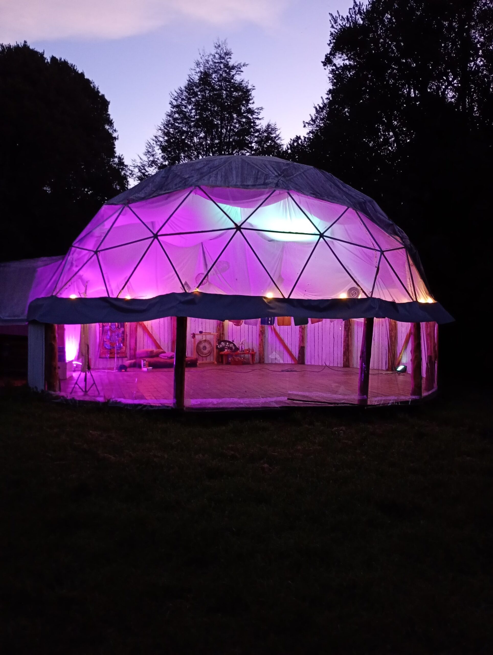 Domo geodésico iluminado de noche en Chakrasana, El Hoyo