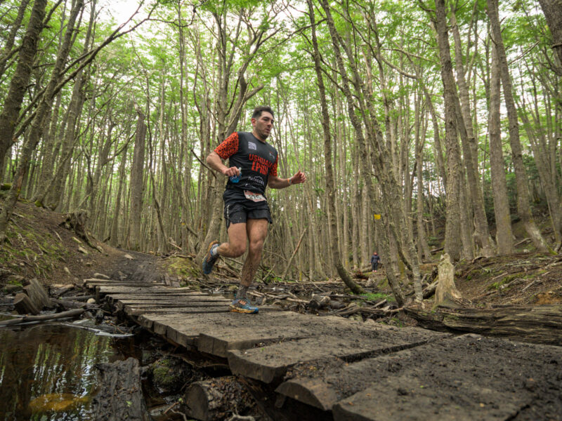 Corredor de trail de la Ushuaia Epic sobre una pasarela de madera en el bosque de lengas de Ushuaia