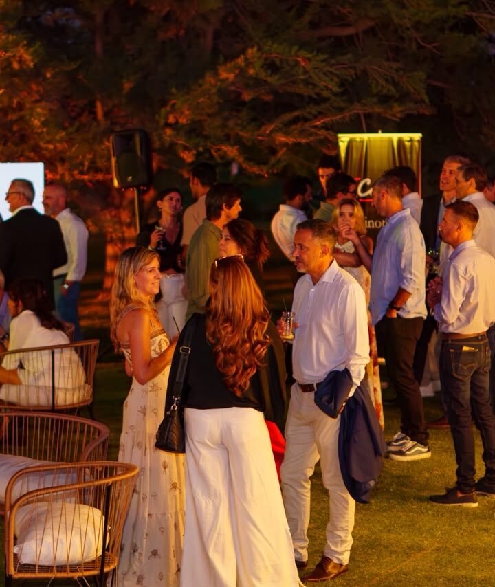 Invitados conversando en el jardín del Comahue Golf Club durante Wine & Business