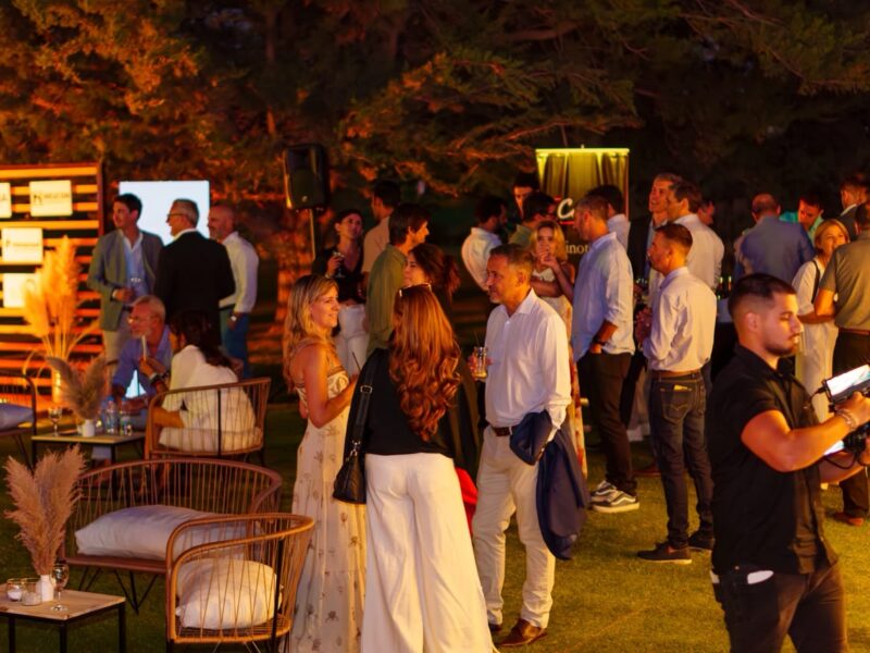 Invitados conversando en el jardín del Comahue Golf Club durante Wine & Business